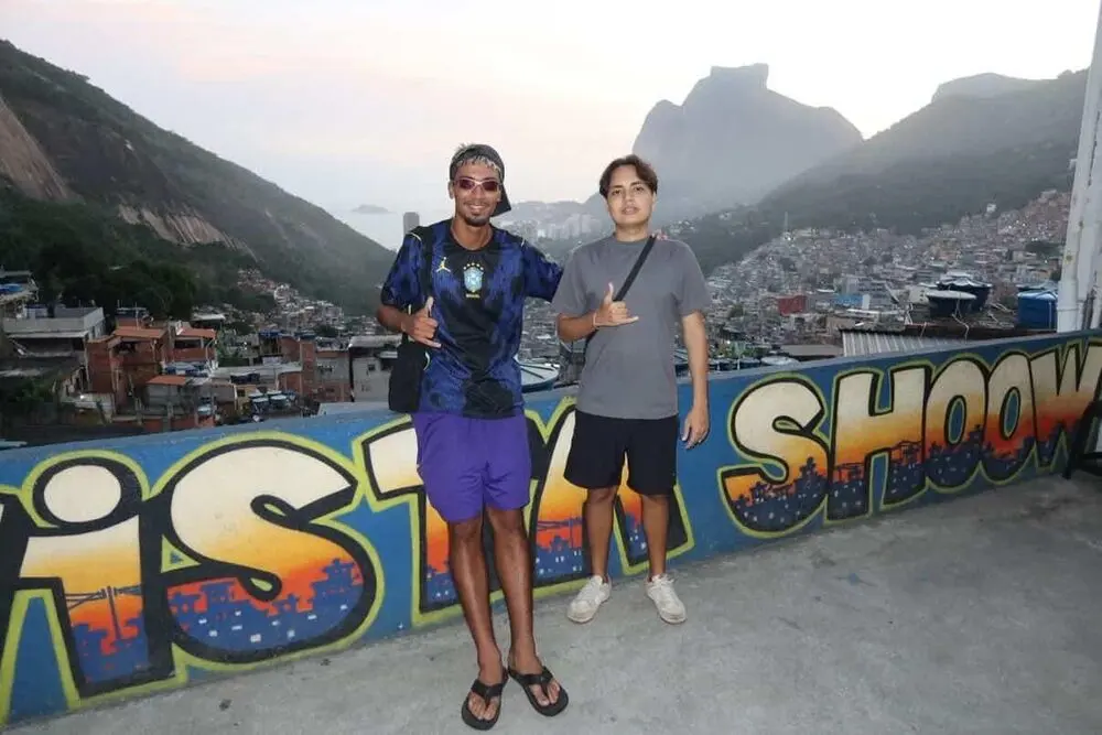 The two Rocinha Cousins guides on a rooftop overlooking the favela and Dois Irmãos mountain