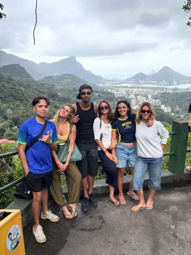 Six travellers and their guide at a Rio viewpoint on a cloudy morning