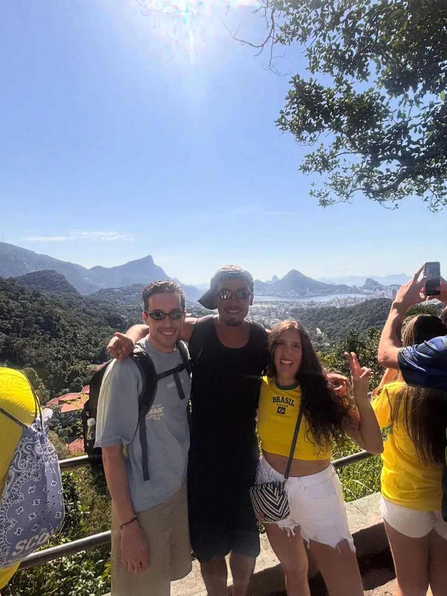 Two travellers with one of the cousins on a clear day, Corcovado and Sugarloaf on the horizon behind them